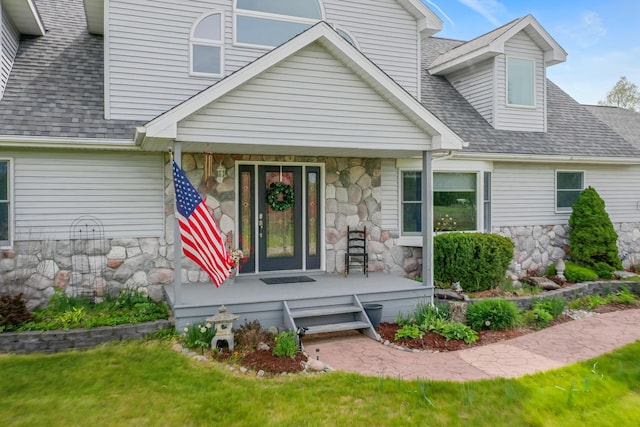 201 Country Ct, Houghton Lake, MI 48629 - view of front of home with stone siding, covered porch, roof with shingles, and a front yard