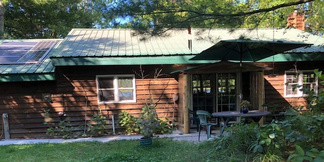 4550 E Simmons Rd, Hessel, MI 49745 - back of house with metal roof and a chimney