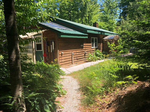4550 E Simmons Rd, Hessel, MI 49745 - view of side of home with metal roof and a chimney
