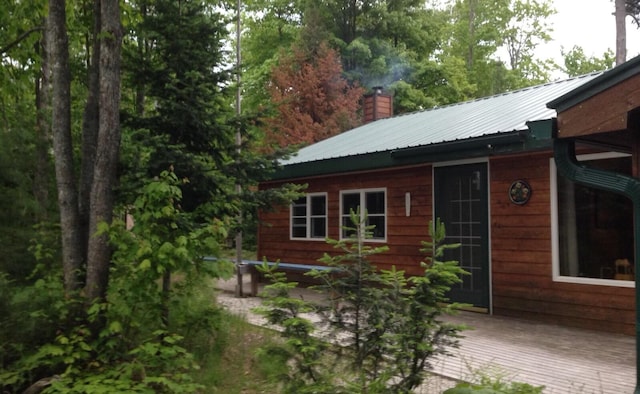 4550 E Simmons Rd, Hessel, MI 49745 - view of property exterior with a chimney and metal roof