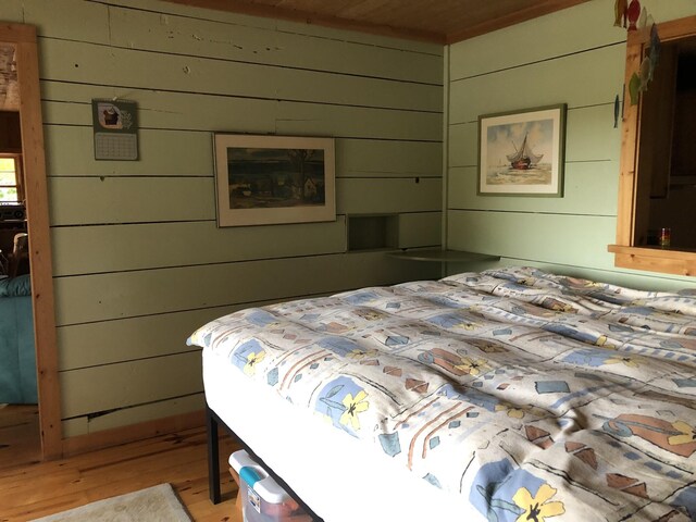 4550 E Simmons Rd, Hessel, MI 49745 - bedroom featuring light wood finished floors, wood walls, and wooden ceiling