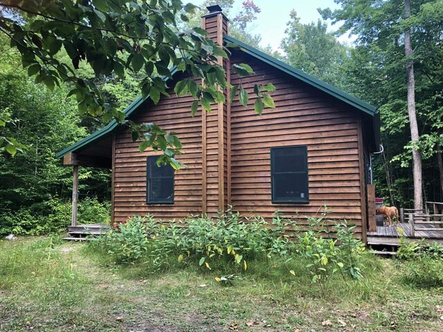 4550 E Simmons Rd, Hessel, MI 49745 - view of property exterior featuring a wooden deck and a chimney