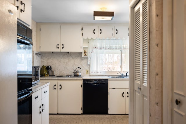 7654 M 32 E, Johannesburg, MI 49751 - kitchen with black appliances, light countertops, tasteful backsplash, a sink, and white cabinets