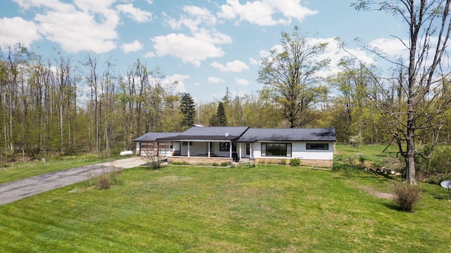 7654 M 32 E, Johannesburg, MI 49751 - view of front of property featuring a porch, driveway, and a front lawn