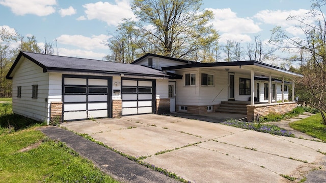 7654 M 32 E, Johannesburg, MI 49751 - split level home with concrete driveway, an attached garage, and covered porch