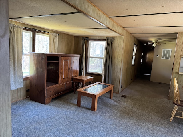1321 Eagle Point Rd, Grayling, MI 49738 - unfurnished living room with wooden walls, healthy amount of natural light, carpet flooring, and ceiling fan