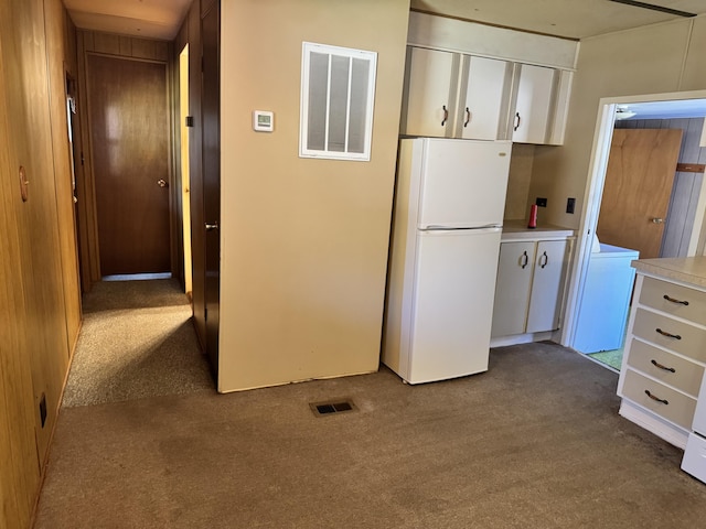 1321 Eagle Point Rd, Grayling, MI 49738 - kitchen with freestanding refrigerator, dark colored carpet, washer / dryer, white cabinetry, and light countertops