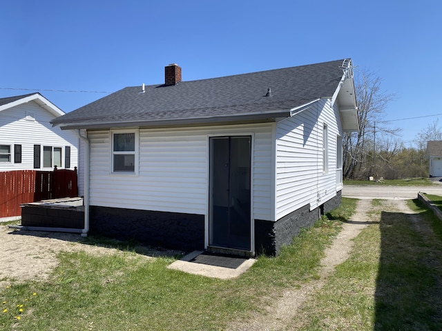 737 S First St, Rogers City, MI 49779 - rear view of house with a chimney and a shingled roof