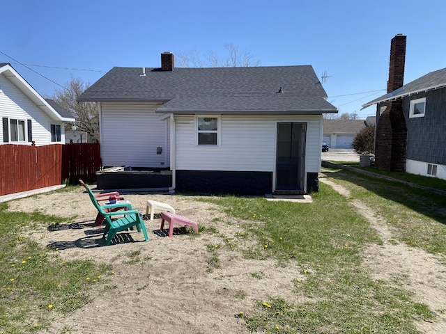 737 S First St, Rogers City, MI 49779 - back of house with a chimney and a shingled roof