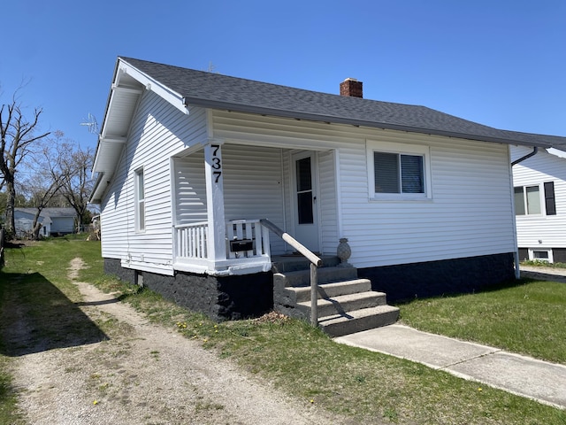 737 S First St, Rogers City, MI 49779 - bungalow-style home featuring a chimney, roof with shingles, and a porch