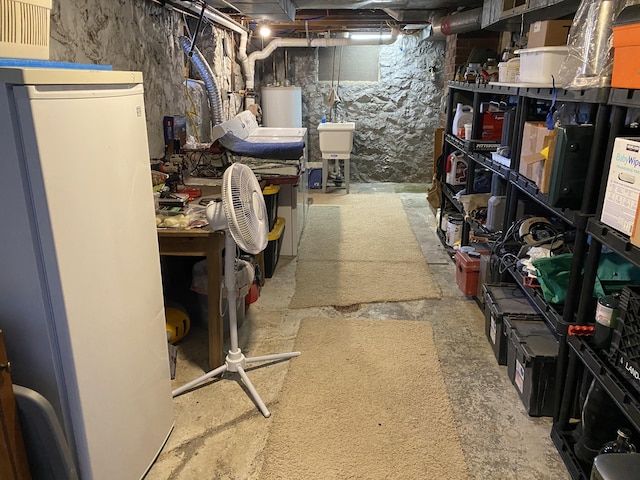 737 S First St, Rogers City, MI 49779 - unfinished below grade area featuring refrigerator and water heater