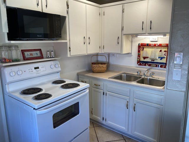 737 S First St, Rogers City, MI 49779 - kitchen featuring white range with electric cooktop, black microwave, a sink, light countertops, and white cabinetry