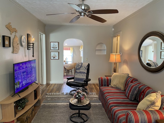 737 S First St, Rogers City, MI 49779 - living room with arched walkways, wood finished floors, ceiling fan, crown molding, and baseboards