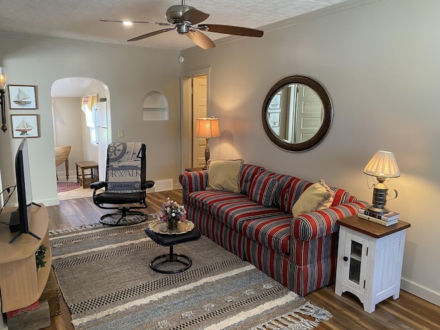 737 S First St, Rogers City, MI 49779 - living room with arched walkways, ornamental molding, wood finished floors, a ceiling fan, and baseboards