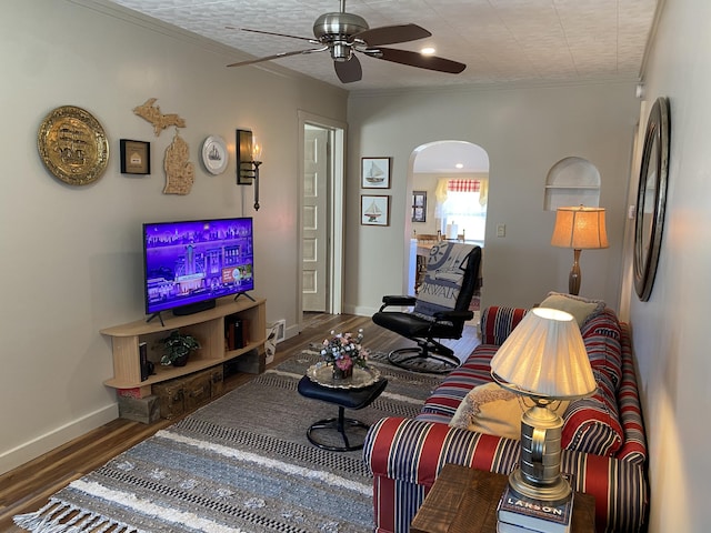 737 S First St, Rogers City, MI 49779 - living room featuring arched walkways, ceiling fan, wood finished floors, ornamental molding, and baseboards