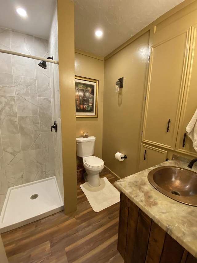 737 S First St, Rogers City, MI 49779 - bathroom with wood finished floors, toilet, a stall shower, recessed lighting, and vanity