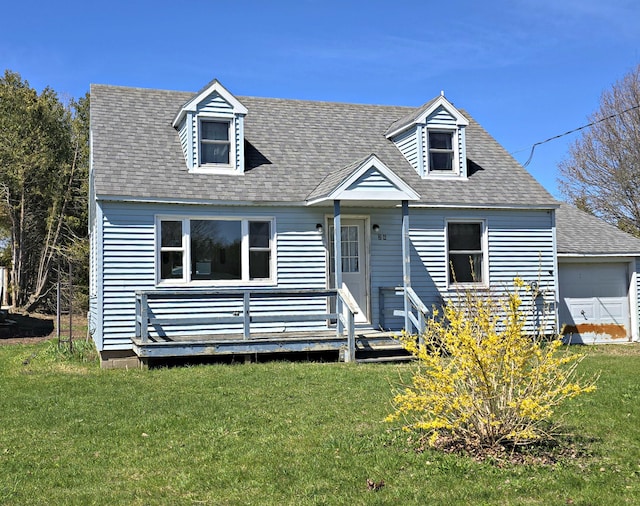 26 Michigan St, Saint Ignace, MI 49781 - cape cod-style house featuring a front lawn, a deck, roof with shingles, and a garage