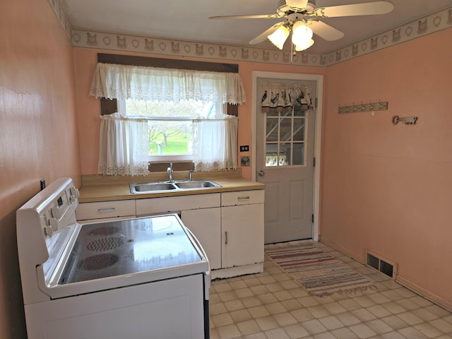 26 Michigan St, Saint Ignace, MI 49781 - kitchen with white electric range oven, a sink, white cabinetry, and light countertops