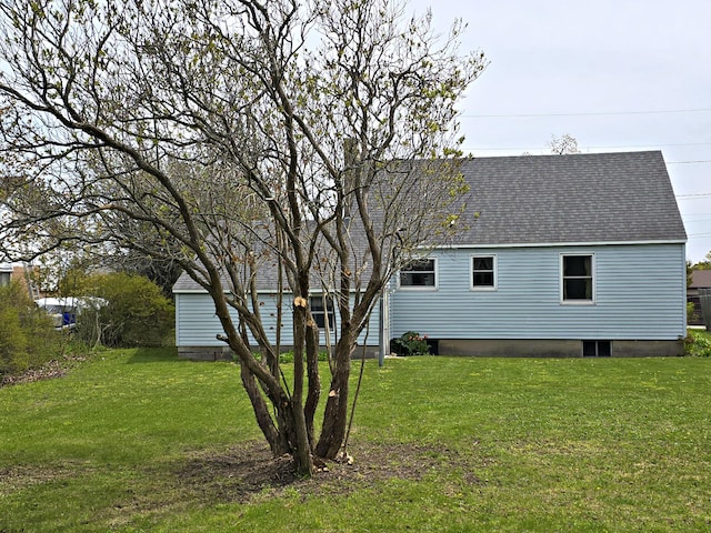 26 Michigan St, Saint Ignace, MI 49781 - rear view of house with roof with shingles and a yard