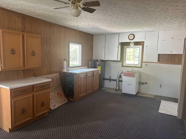 1371 Wayne Rd, Alpena, MI 49707 - kitchen featuring ceiling fan, light countertops, a textured ceiling, wooden walls, and dark carpet