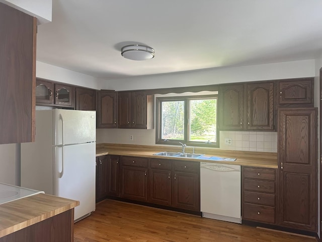 1371 Wayne Rd, Alpena, MI 49707 - kitchen featuring a sink, white appliances, backsplash, and dark brown cabinetry