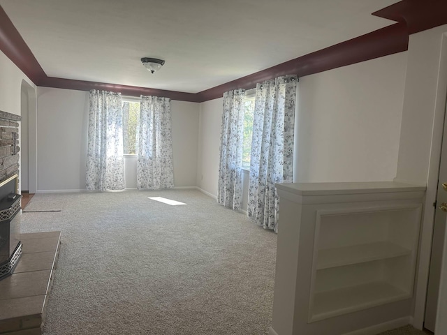 1371 Wayne Rd, Alpena, MI 49707 - unfurnished living room featuring carpet, a stone fireplace, and baseboards