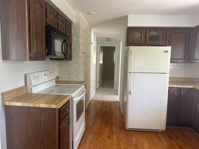 1371 Wayne Rd, Alpena, MI 49707 - kitchen with white appliances, dark brown cabinetry, wood finished floors, light countertops, and backsplash