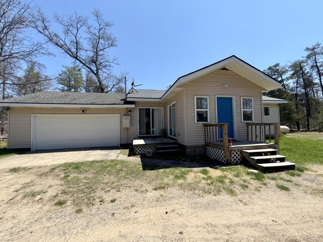 1073 S Hoot Owl Ln, Grayling, MI 49738 - view of front facade featuring driveway, a garage, a wooden deck, and a shingled roof