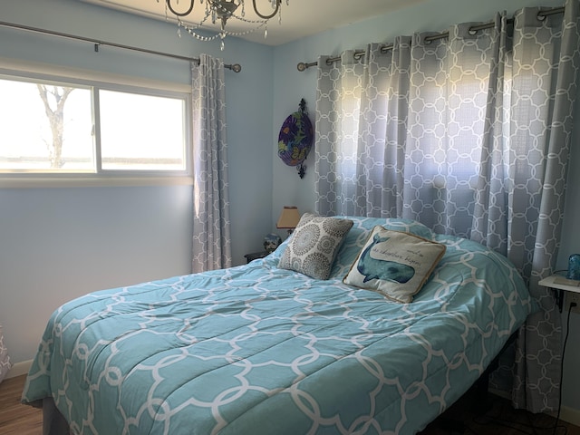 bedroom featuring wood finished floors and a chandelier