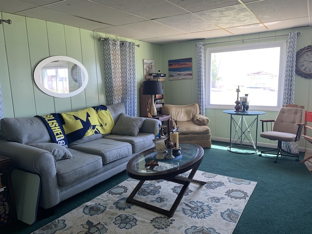 carpeted living area featuring a drop ceiling