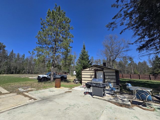 3625 Mckinley Rd, Mio, MI 48647 - view of patio featuring grilling area, a storage unit, fence, and an outdoor structure