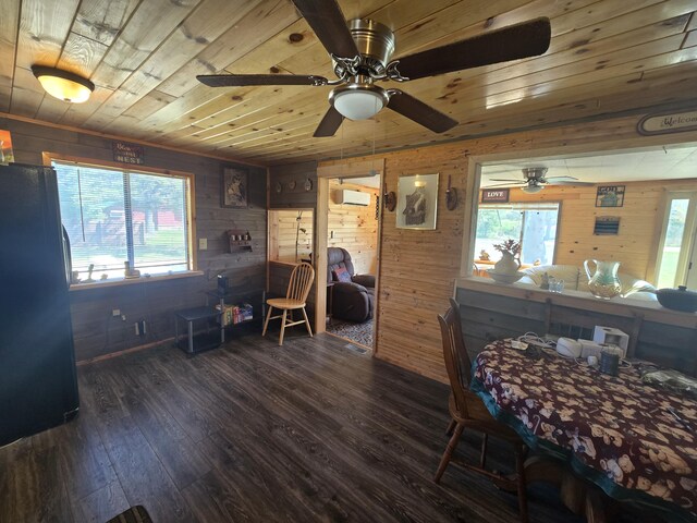 3625 Mckinley Rd, Mio, MI 48647 - bedroom with a wall mounted AC, wooden walls, freestanding refrigerator, multiple windows, and dark wood-style flooring