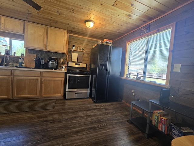 3625 Mckinley Rd, Mio, MI 48647 - kitchen with black fridge with ice dispenser, stainless steel gas stove, plenty of natural light, dark wood-type flooring, and wood walls