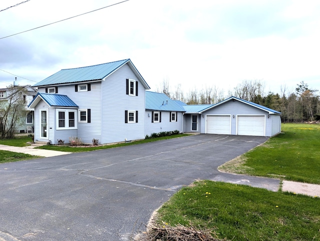 615 Duncan Ave, Cheboygan, MI 49721 - view of front of property with metal roof, asphalt driveway, a front yard, and an attached garage