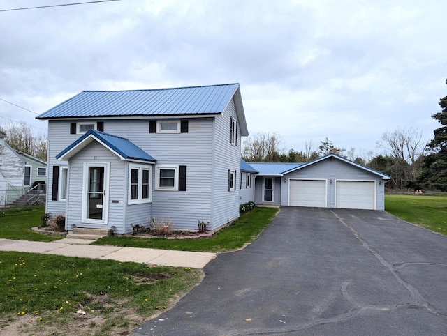 615 Duncan Ave, Cheboygan, MI 49721 - view of front facade with metal roof, a front lawn, asphalt driveway, entry steps, and a garage