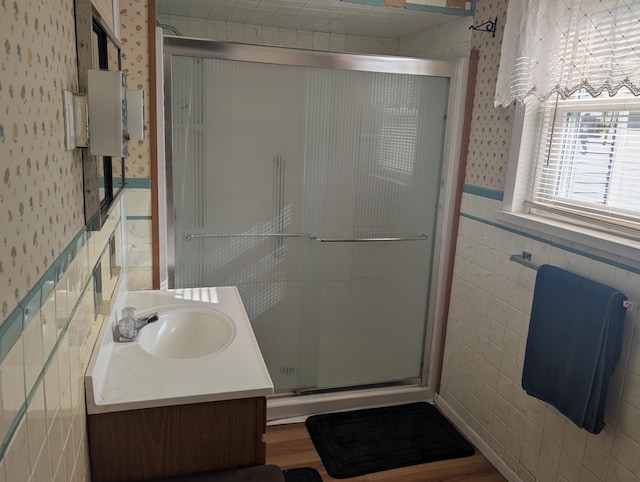 615 Duncan Ave, Cheboygan, MI 49721 - bathroom featuring wallpapered walls, tile walls, a shower stall, wainscoting, and vanity