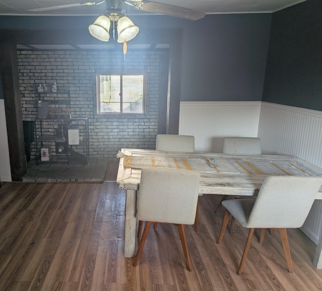 615 Duncan Ave, Cheboygan, MI 49721 - dining room with wood finished floors, a wainscoted wall, brick wall, and a ceiling fan