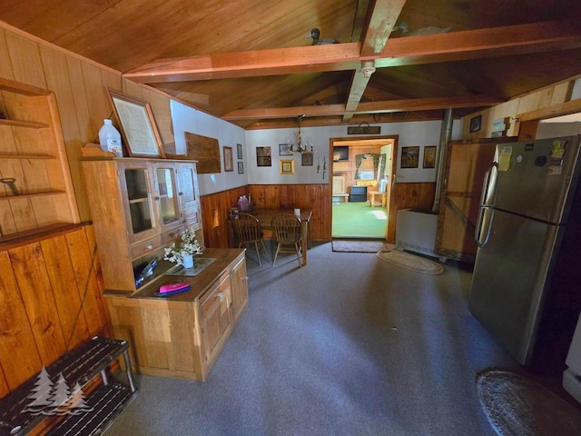 4097 Sunset Dr, Lewiston, MI 49756 - kitchen with freestanding refrigerator, wooden walls, wainscoting, wooden ceiling, and carpet flooring