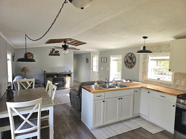 10340 US-23, Cheboygan, MI 49721 - kitchen featuring butcher block counters, a sink, stainless steel gas range oven, dark wood-style flooring, and crown molding