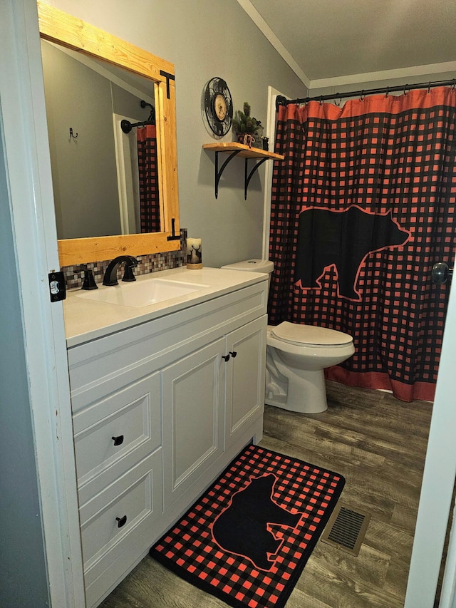 10340 US-23, Cheboygan, MI 49721 - bathroom with wood finished floors, ornamental molding, vanity, and toilet
