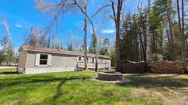 10340 US-23, Cheboygan, MI 49721 - manufactured / mobile home featuring an outdoor fire pit, a front yard, and a wooden deck