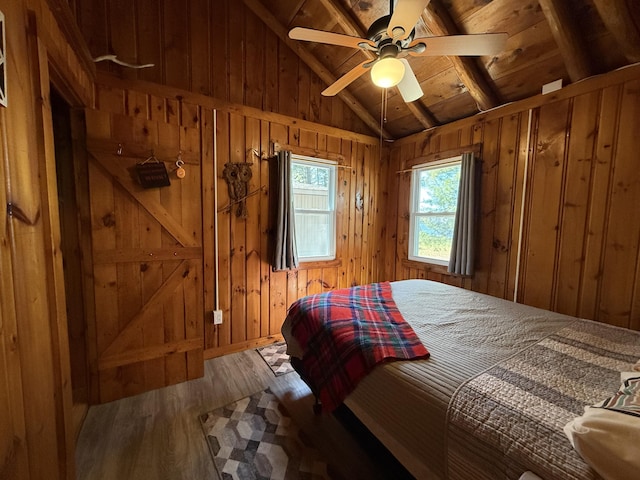 6299 Woodland Dr, Oscoda, MI 48750 - bedroom featuring wood finished floors, wooden walls, wood ceiling, and a ceiling fan