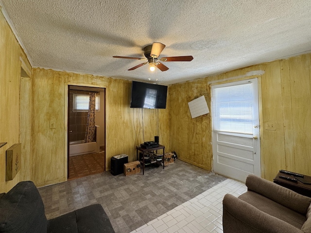 1654 Opland Rd, Gladwin, MI 48624 - living room with wooden walls, ceiling fan, and a textured ceiling