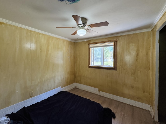 1654 Opland Rd, Gladwin, MI 48624 - unfurnished bedroom with wood finished floors, ceiling fan, baseboards, and ornamental molding