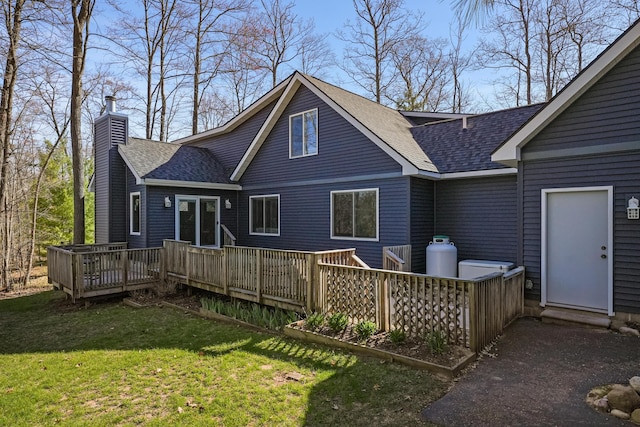 343 Crystal Ln, Roscommon, MI 48653 - back of property featuring roof with shingles, a chimney, a wooden deck, and a yard