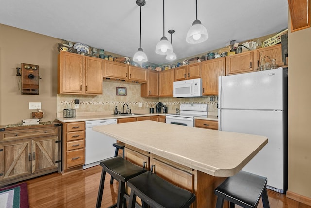 343 Crystal Ln, Roscommon, MI 48653 - kitchen with white appliances, light wood finished floors, light countertops, and a breakfast bar