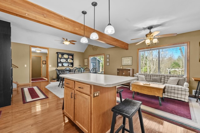 343 Crystal Ln, Roscommon, MI 48653 - kitchen with a ceiling fan, open floor plan, a breakfast bar area, and light wood-style flooring