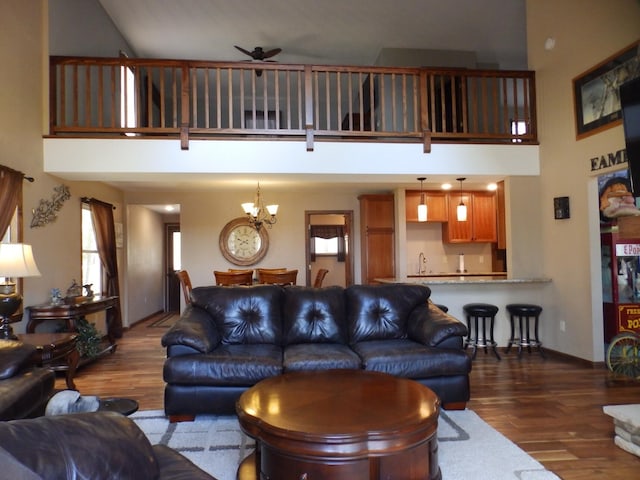 7928 Blueberry Ln, Johannesburg, MI 49751 - living room featuring wood finished floors, a towering ceiling, a ceiling fan, and a chandelier