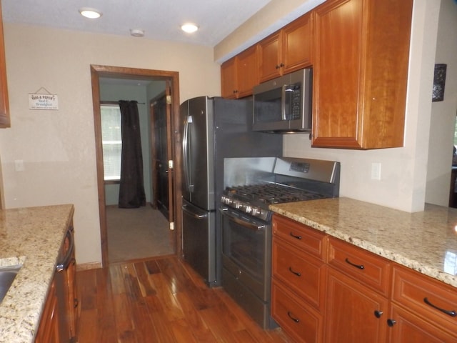 7928 Blueberry Ln, Johannesburg, MI 49751 - kitchen with appliances with stainless steel finishes, dark wood-type flooring, brown cabinetry, and light stone countertops