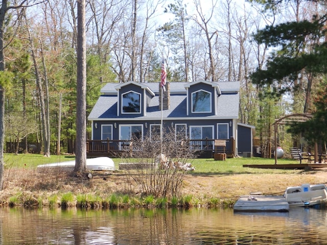 7928 Blueberry Ln, Johannesburg, MI 49751 - view of front facade featuring a deck with water view, a front yard, and roof with shingles